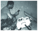 Black and white image of soldier interacting with electronics.